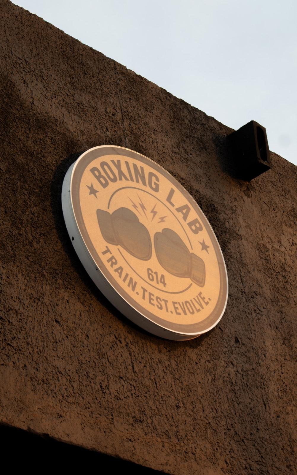 Placa con el logotipo de Boxing Lab 614 en la pared